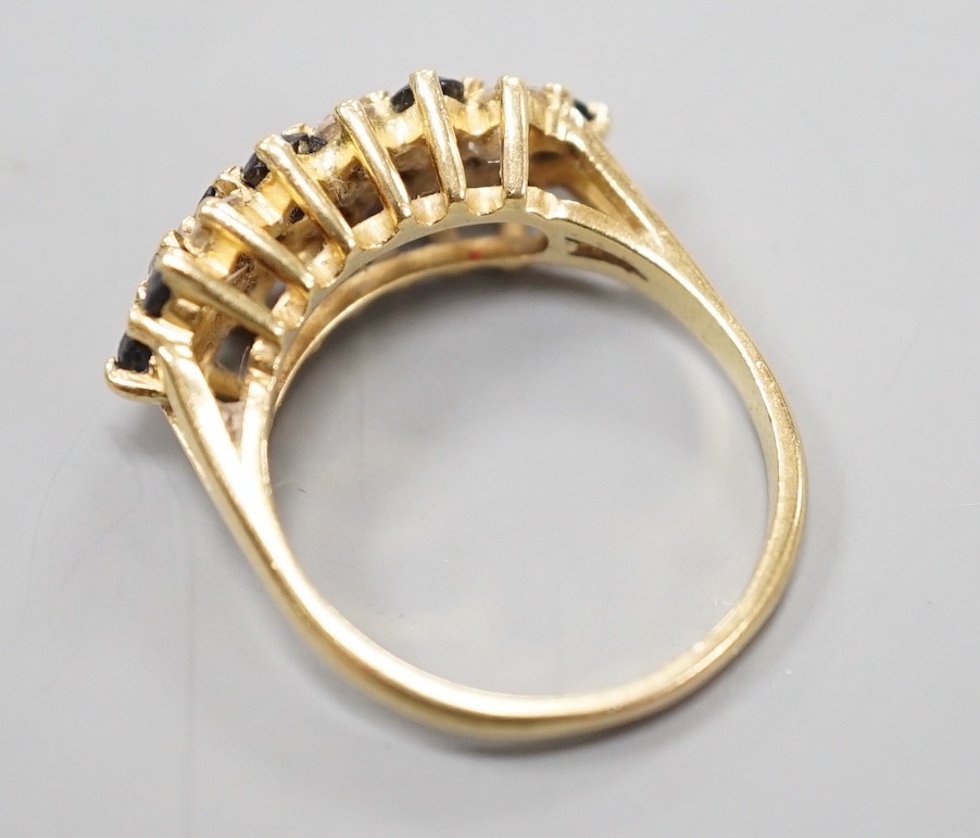 A modern 18ct, sapphire and diamond cluster set seven row half hoop ring, size P, gross weight 5.4 grams.